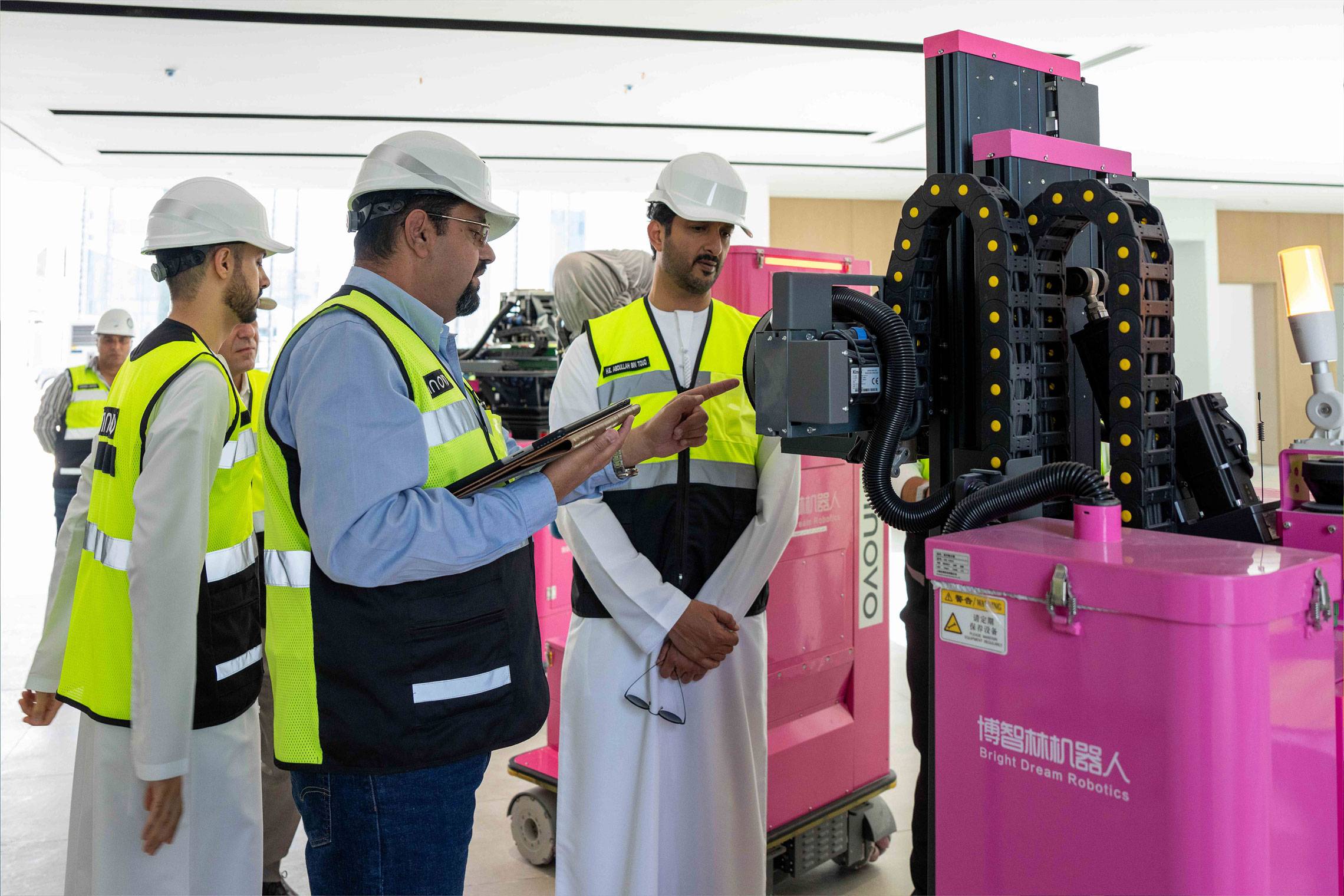 Innovo engineer demonstrates construction robotics on a tablet to a UAE official