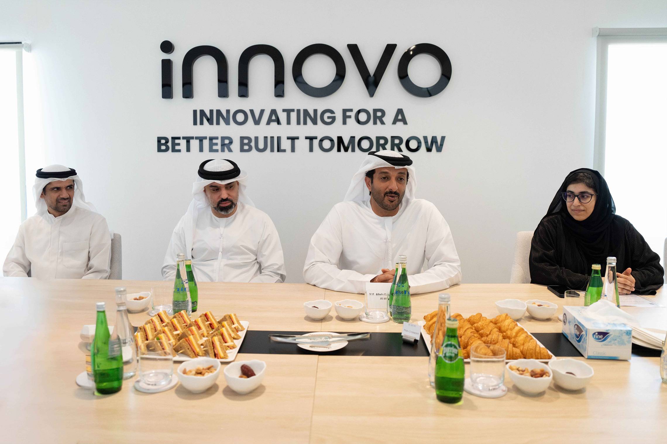 UAE officials at an Innovo meeting beneath the 'Innovating for a better built tomorrow' sign
